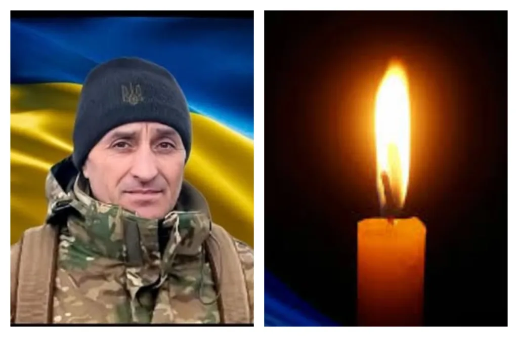 Український військовий та свіча пам’яті на фоні прапора