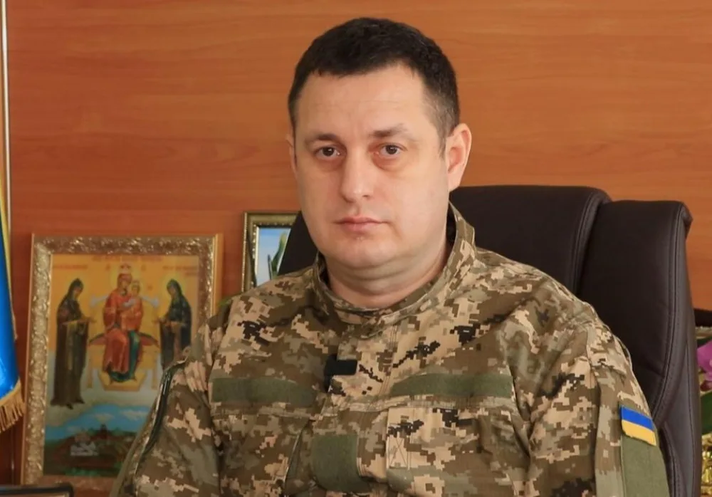 Український військовий у камуфляжі сидить у кабінеті