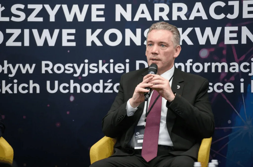 Чоловік виступає на конференції з мікрофоном