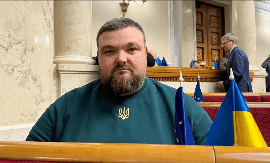 Чоловік у парламенті з прапорами України та ЄС