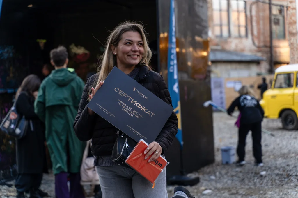 Жінка тримає сертифікат на вулиці