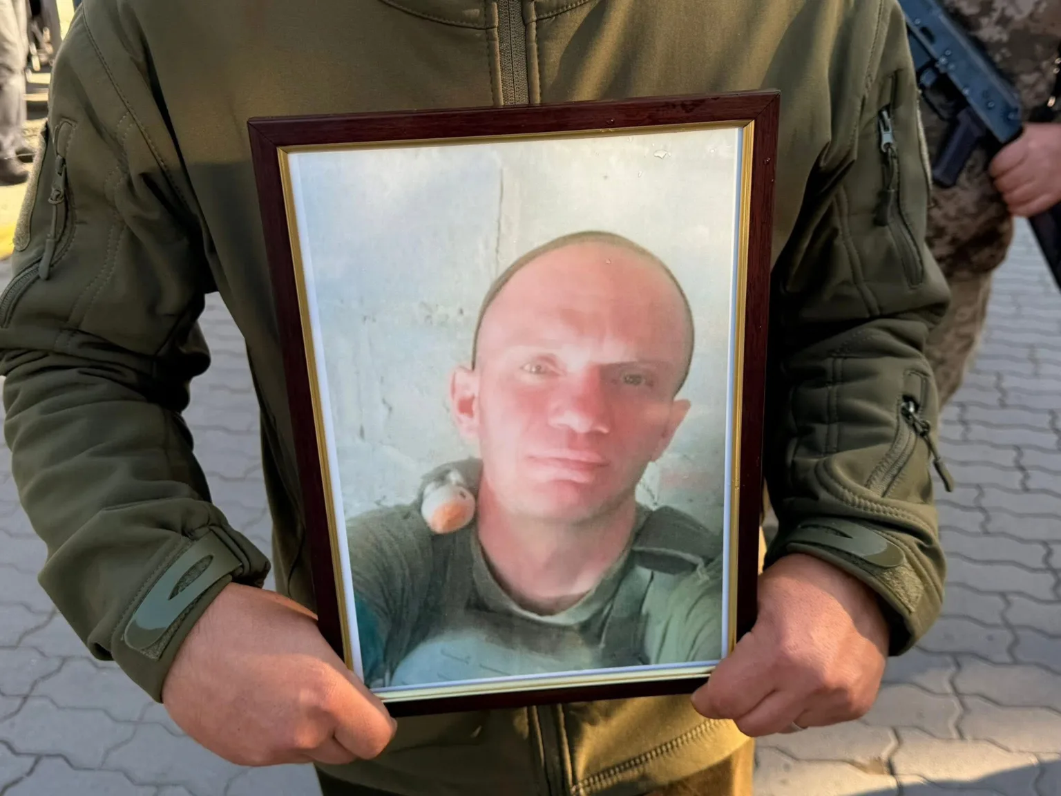 Військовий тримає фото загиблого солдата