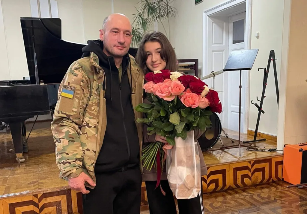 Військовий з дівчиною тримають букет троянд