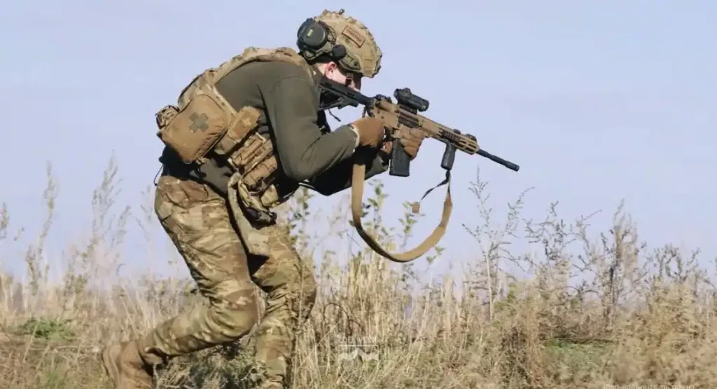 Військовий у камуфляжі з гвинтівкою на полі бою