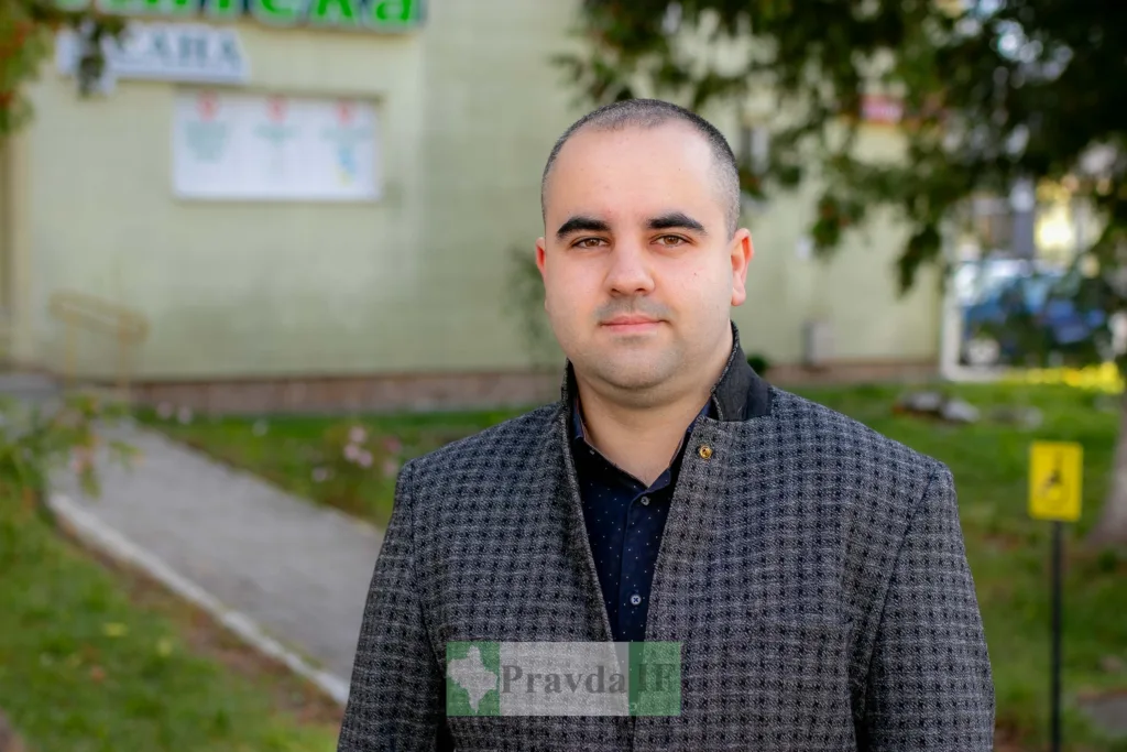 Чоловік стоїть надворі біля будівлі