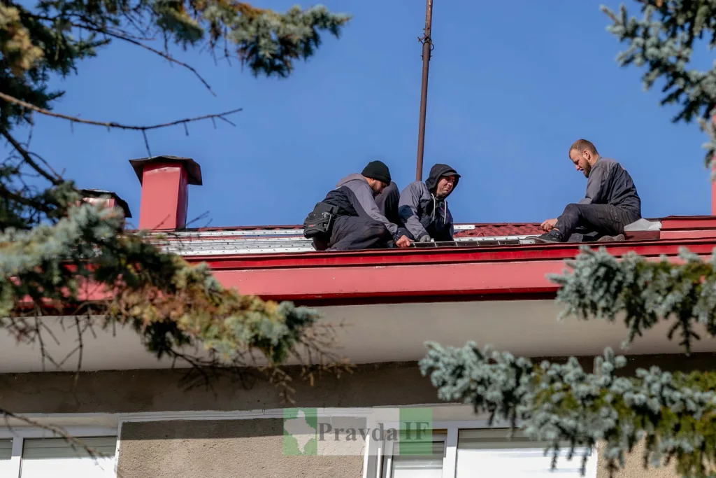 Робітники ремонтують дах будинку