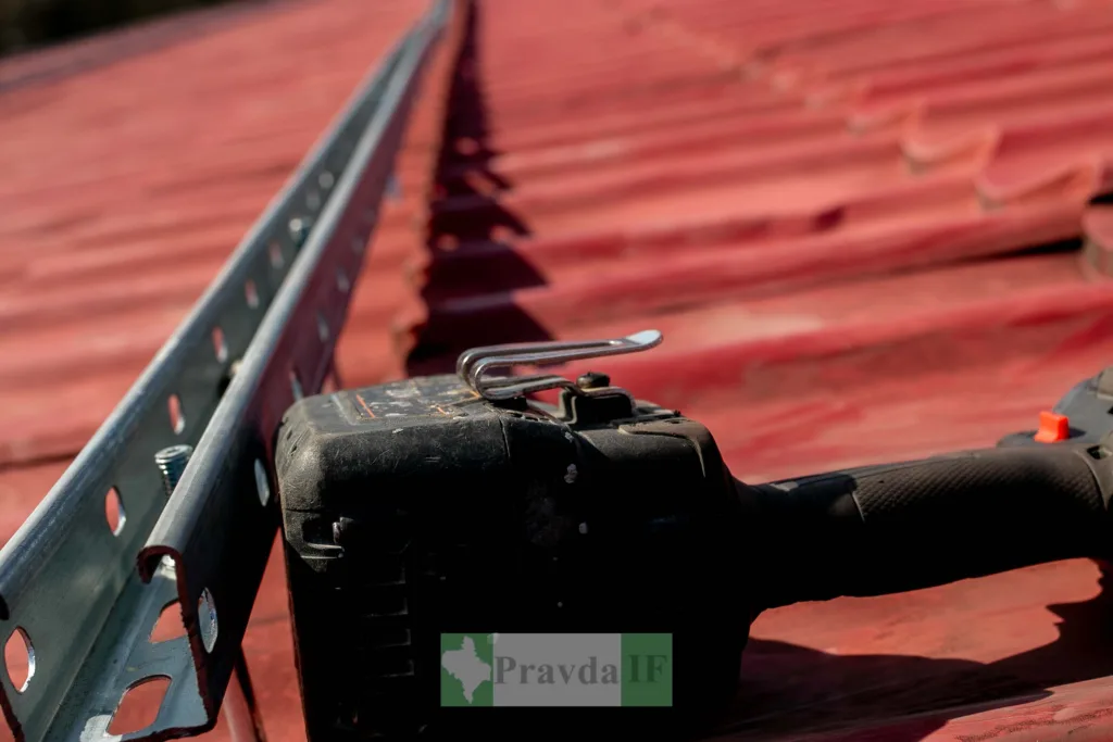 Монтаж металевої рейки на червоному даху