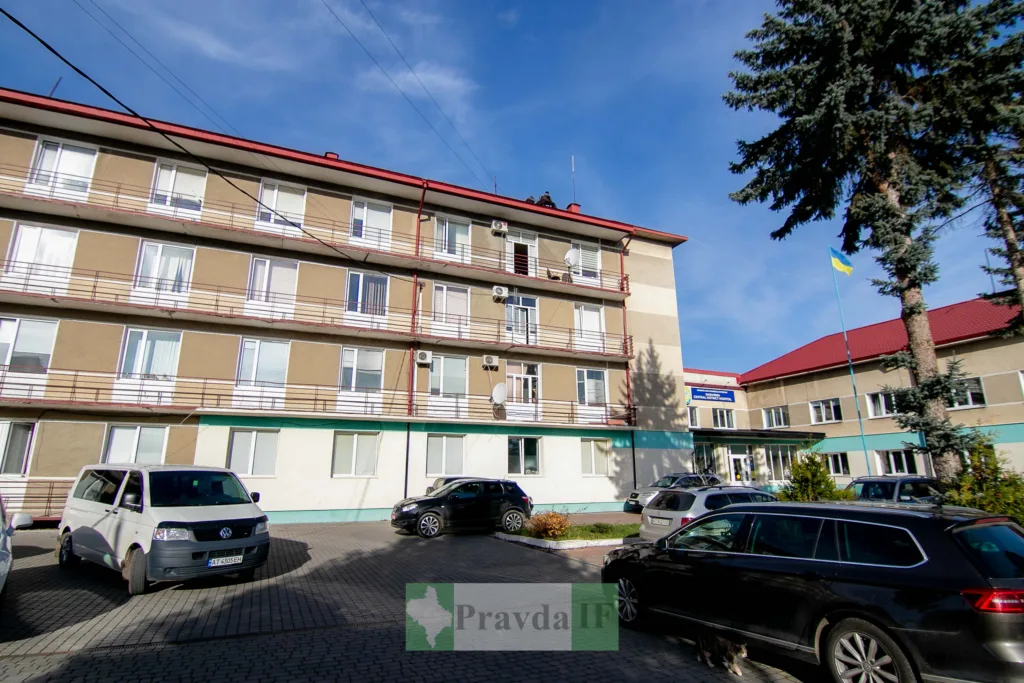 Будівля міської лікарні з припаркованими автомобілями