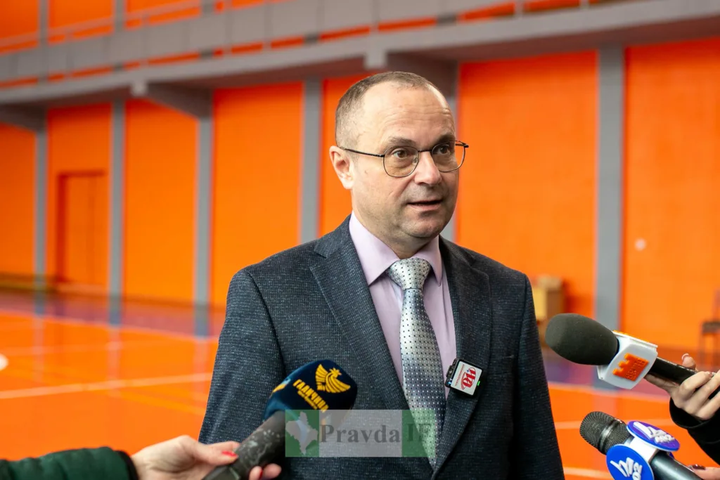 Чоловік дає інтерв'ю журналістам у спортивній залі