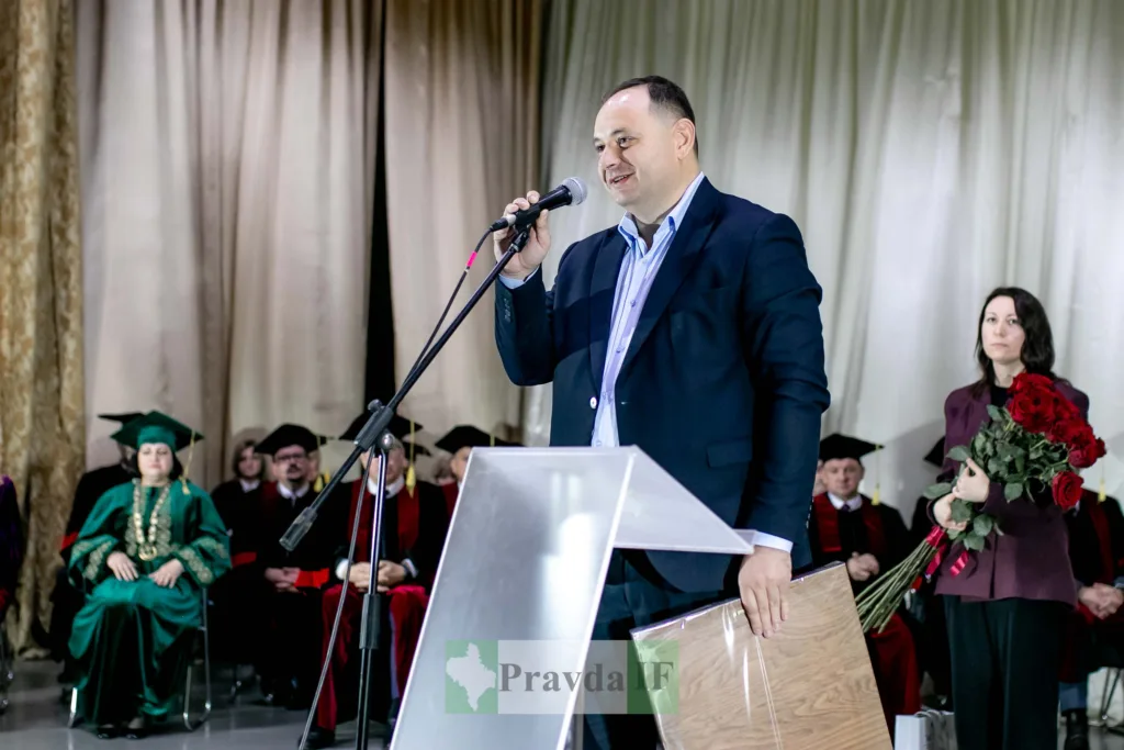 Чоловік виступає на урочистій церемонії з мікрофоном