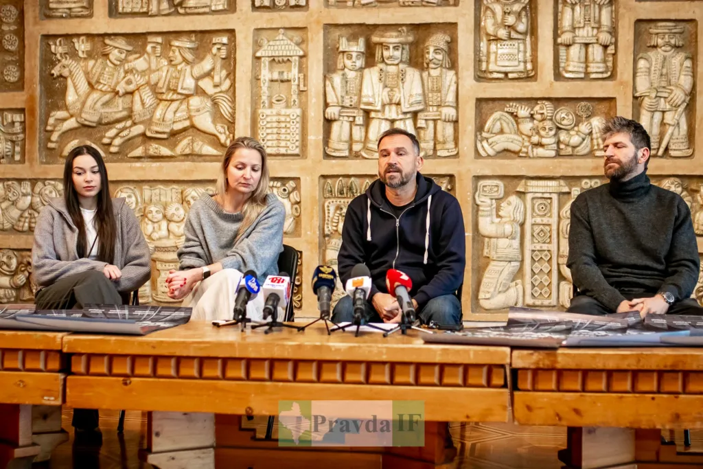 Пресконференція перед мікрофонами на фоні барельєфів