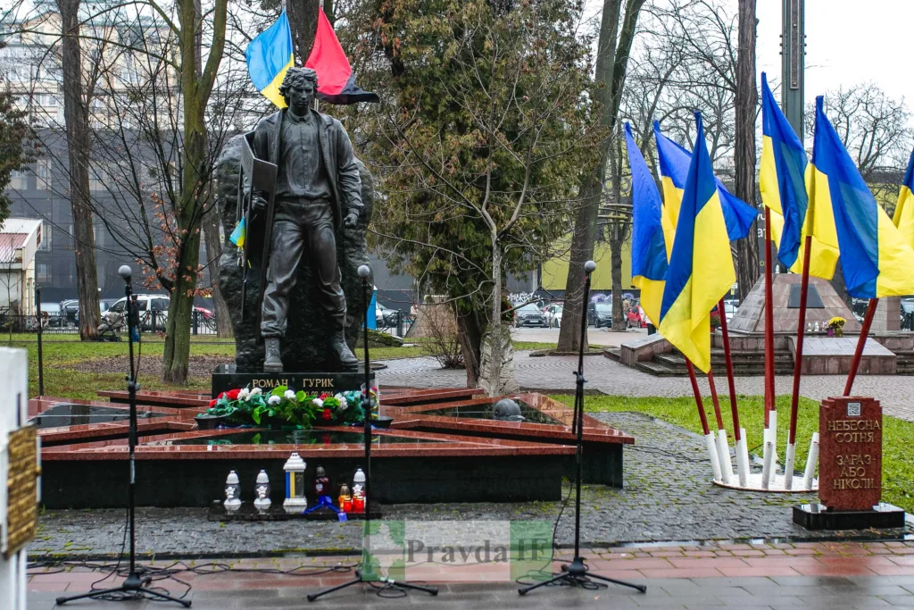 Пам'ятник Герою Небесної Сотні з українськими прапорами