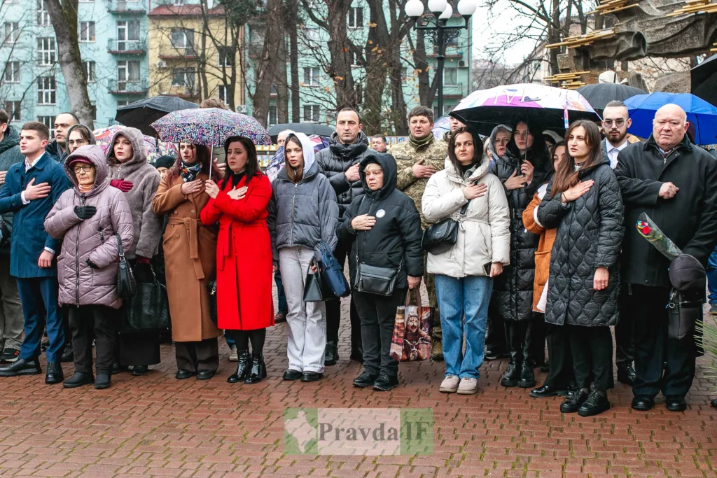 Люди стоять з руками на серці під час церемонії