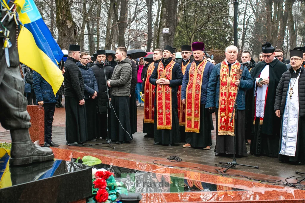 Священники моляться біля пам’ятника з українським прапором