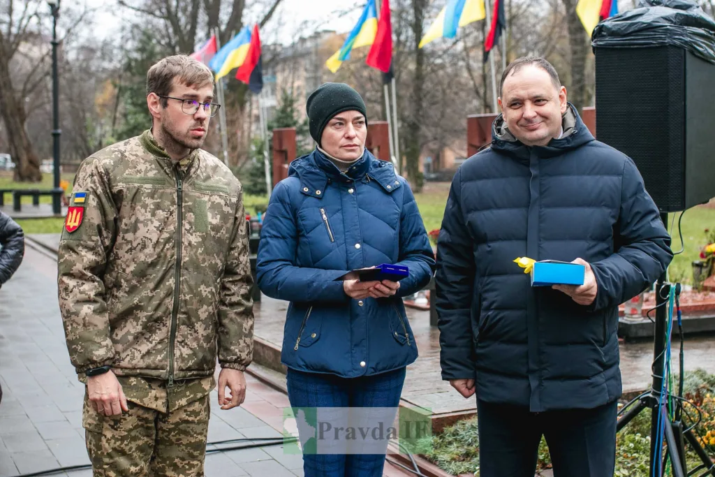 Військовий та двоє людей на церемонії нагородження