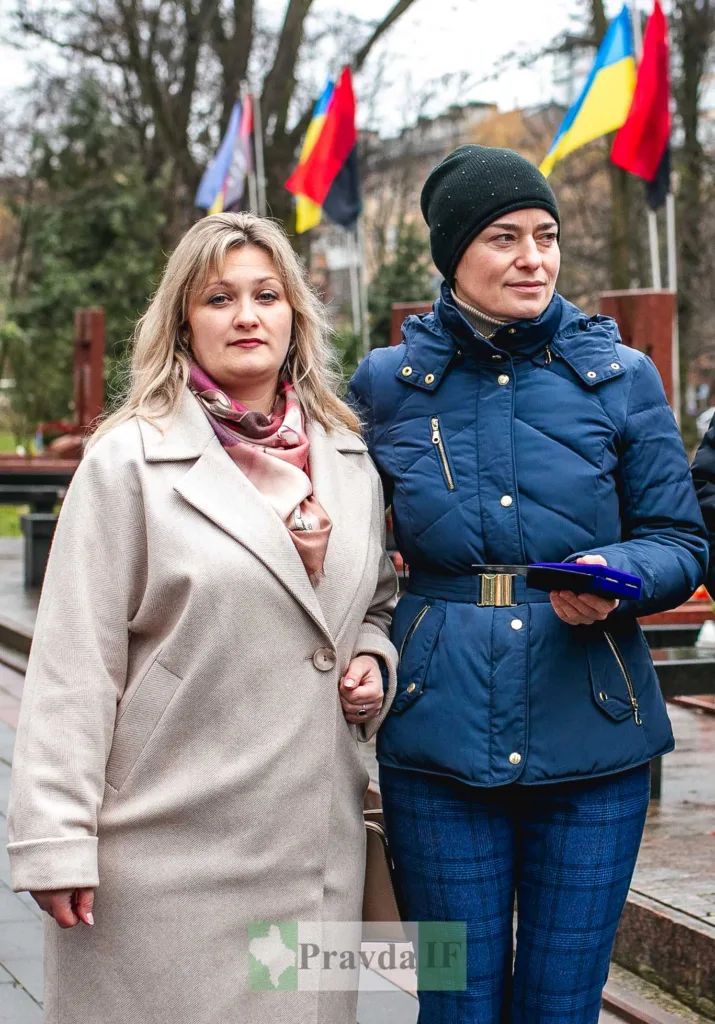 Дві жінки на вулиці з прапорами позаду