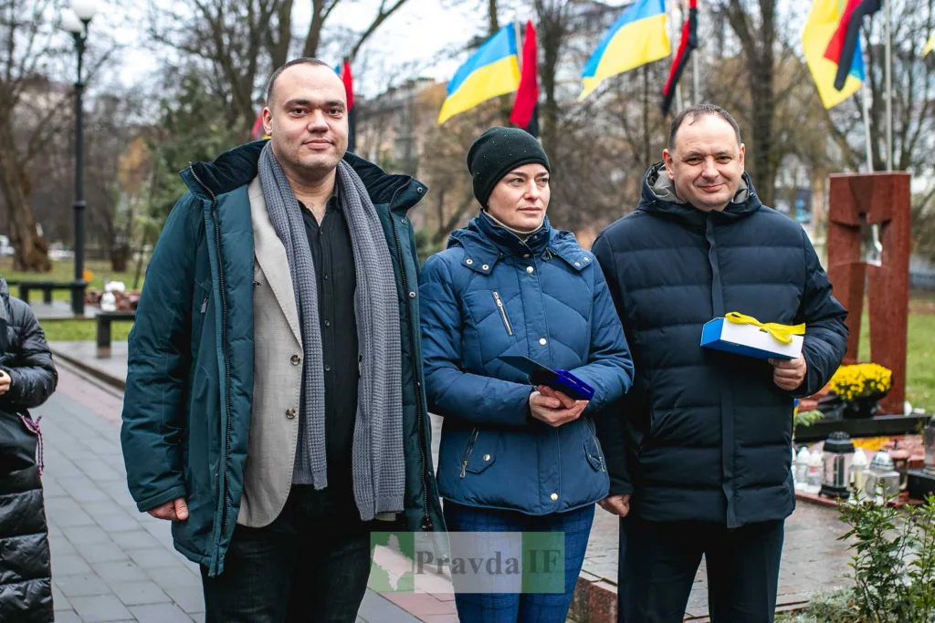 Люди на церемонії з українськими прапорами