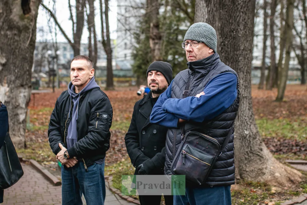 Люди стоять у парку восени