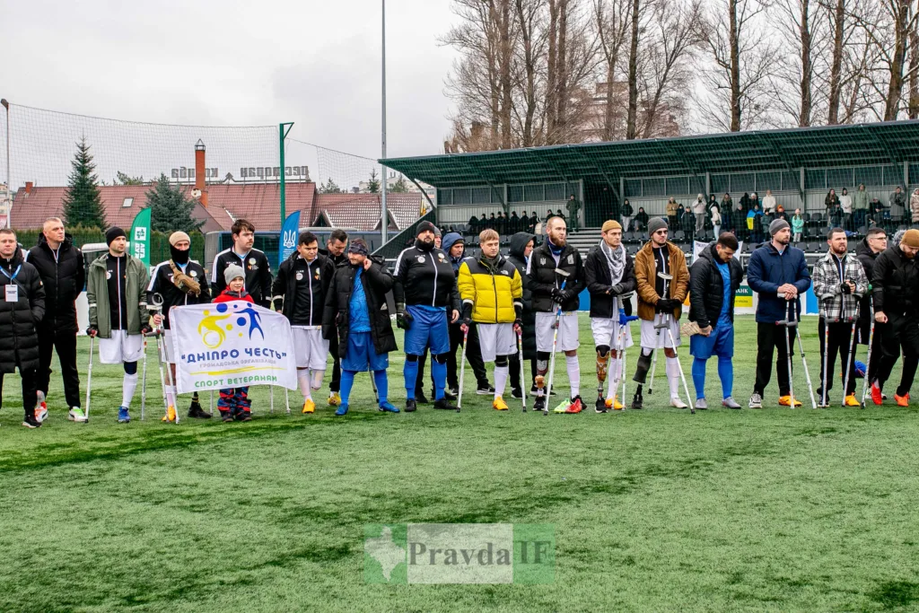 Ветерани футболісти на полі з прапором організації