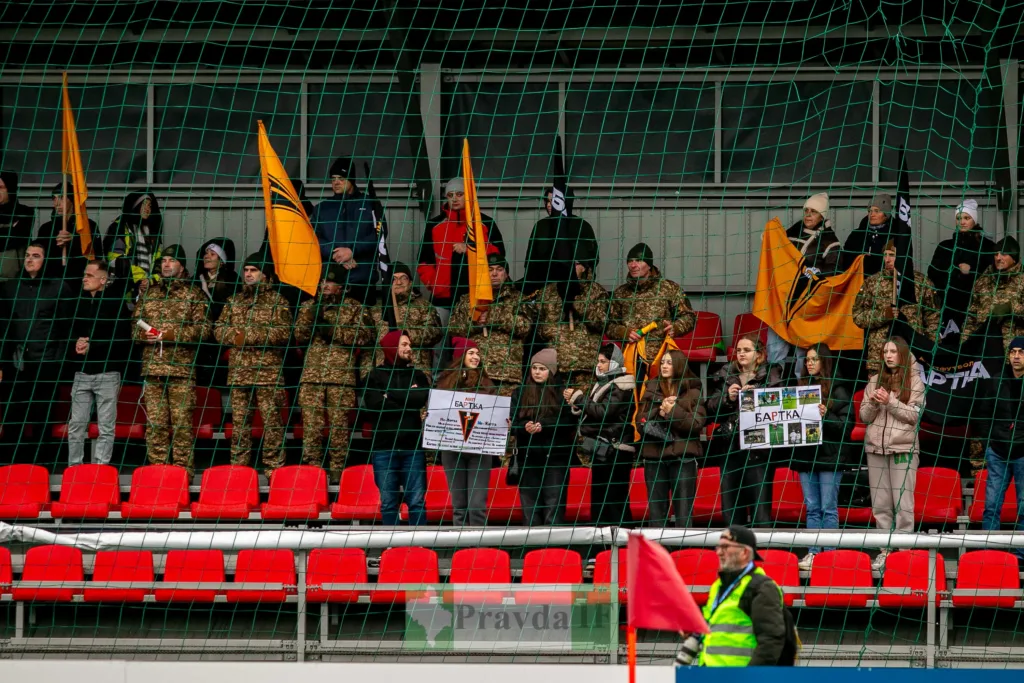 Вболівальники на трибуні з прапорами та плакатами