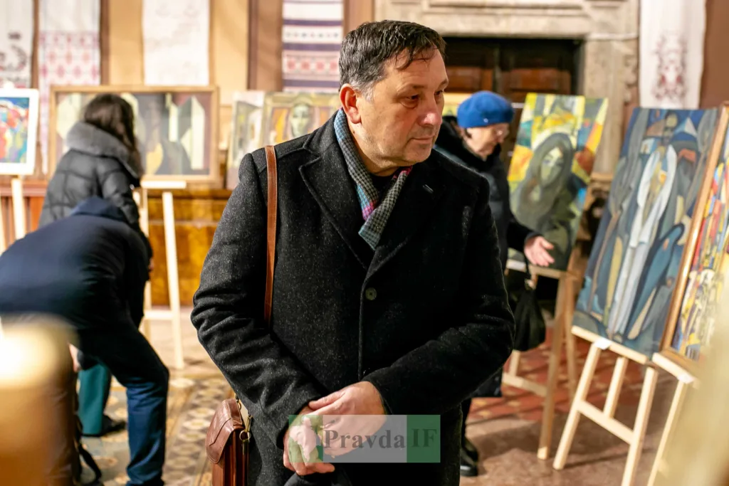 Люди оглядають картини на художній виставці