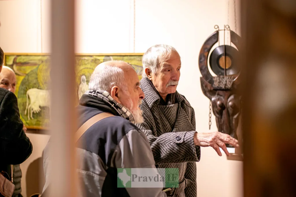 Літні чоловіки оглядають твори мистецтва в галереї