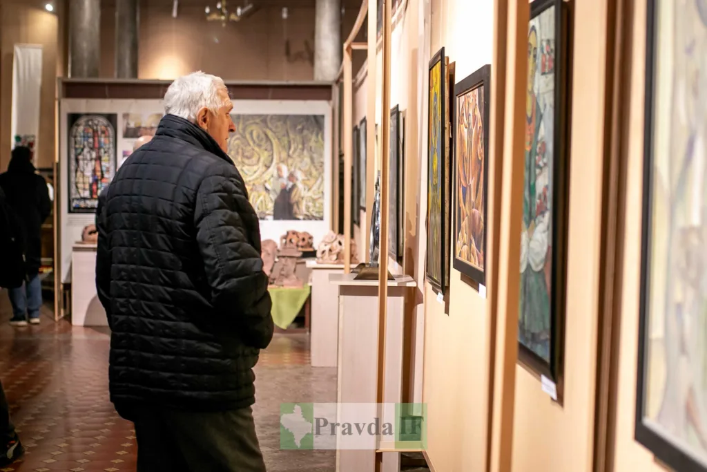 Чоловік розглядає картини в художній галереї