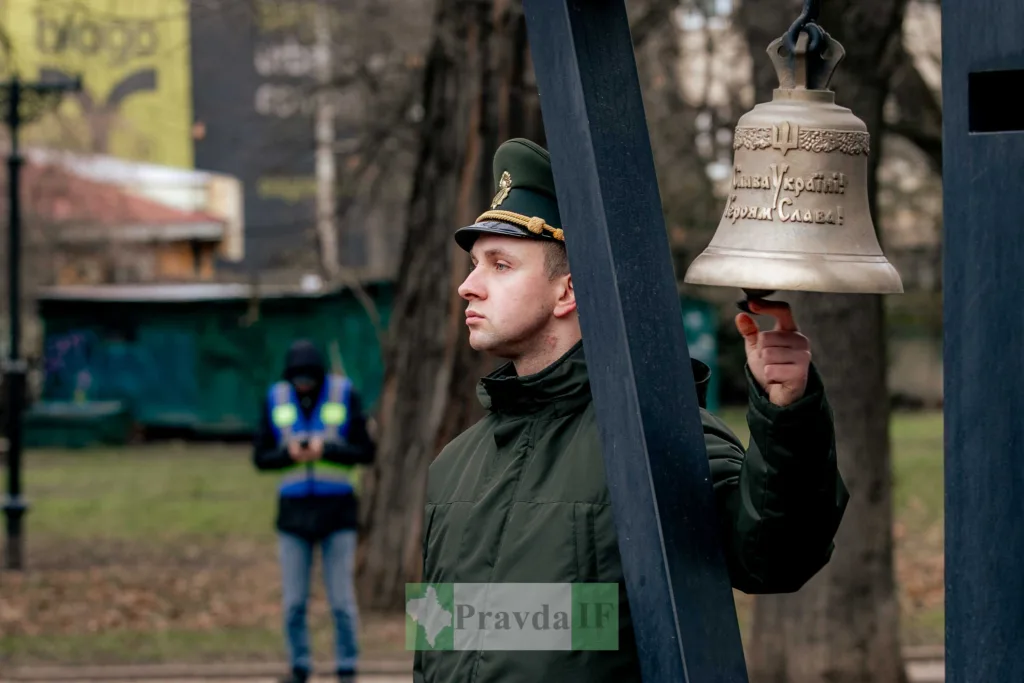 Військовий дзвонить у дзвін на вулиці