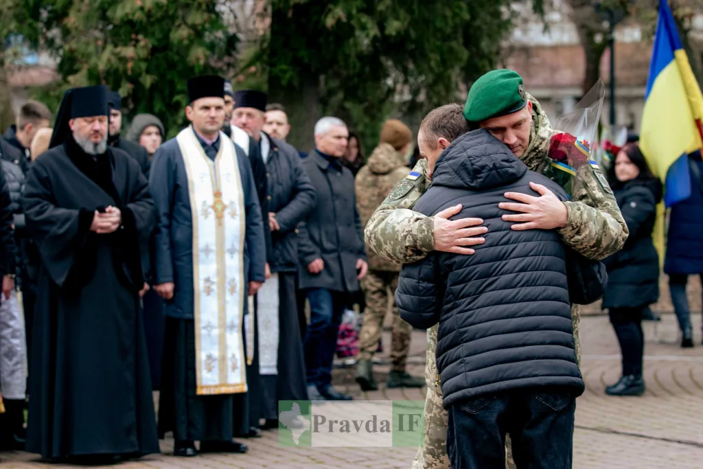 Український військовий обіймає чоловіка під час церемонії