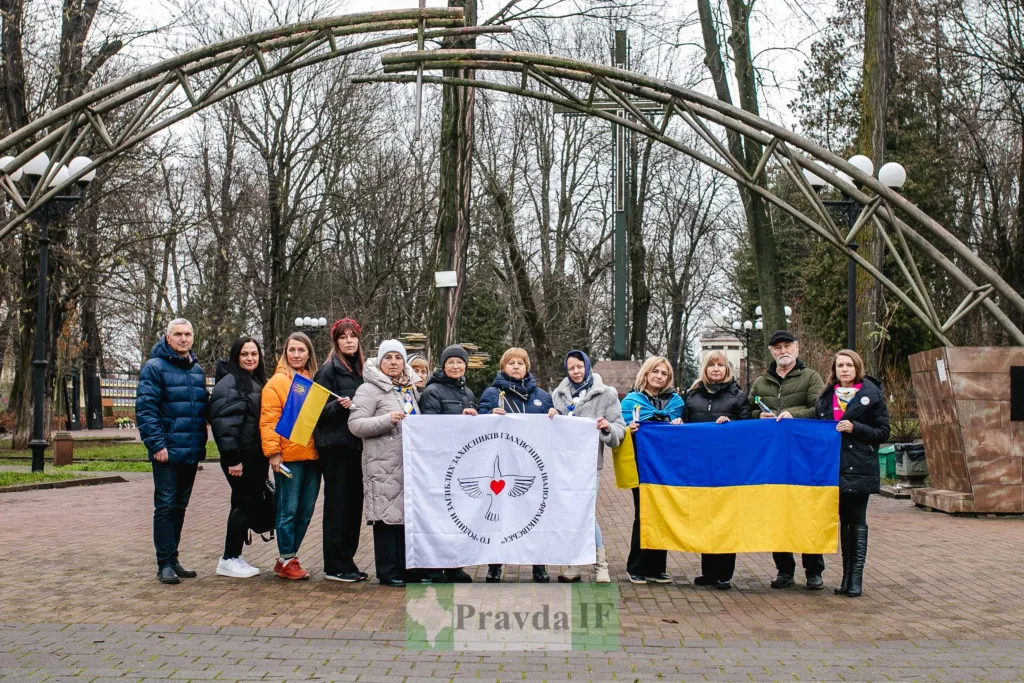 Група людей з українськими прапорами у парку