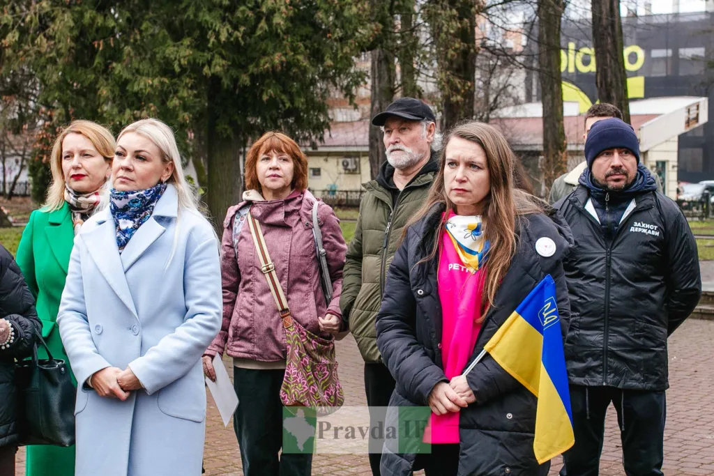 Люди на мітингу з українським прапором