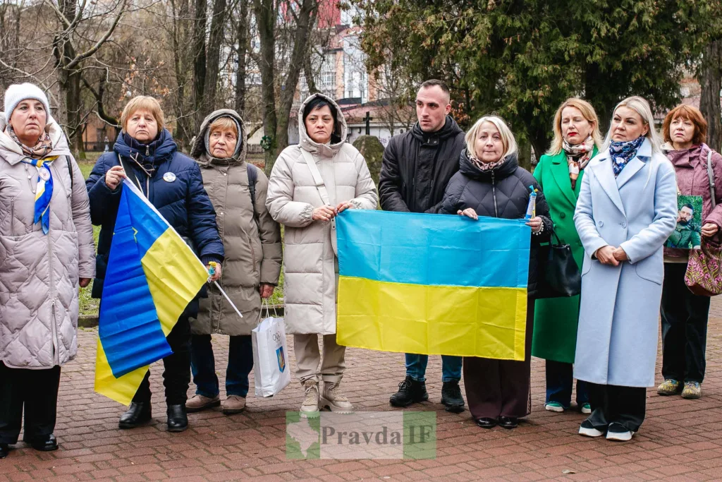 Люди тримають українські прапори на вуличному заході