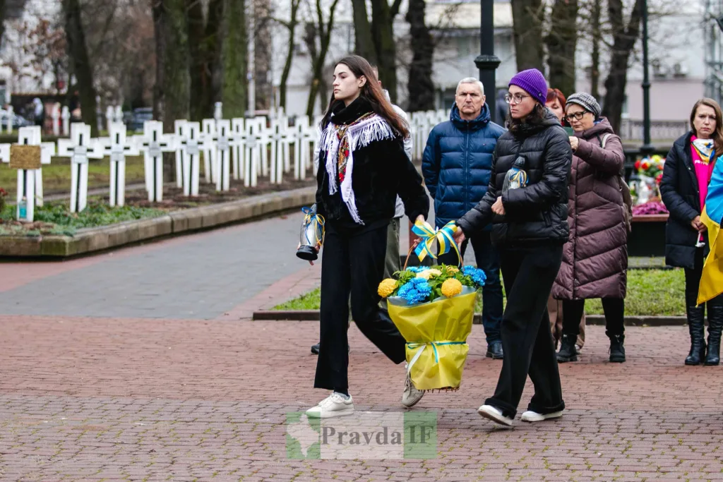 Люди несуть квіти до меморіалу героїв України