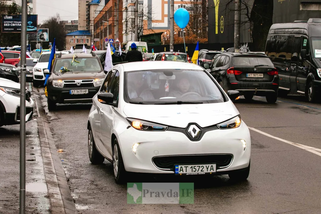Автоколона з українськими прапорами на міській вулиці