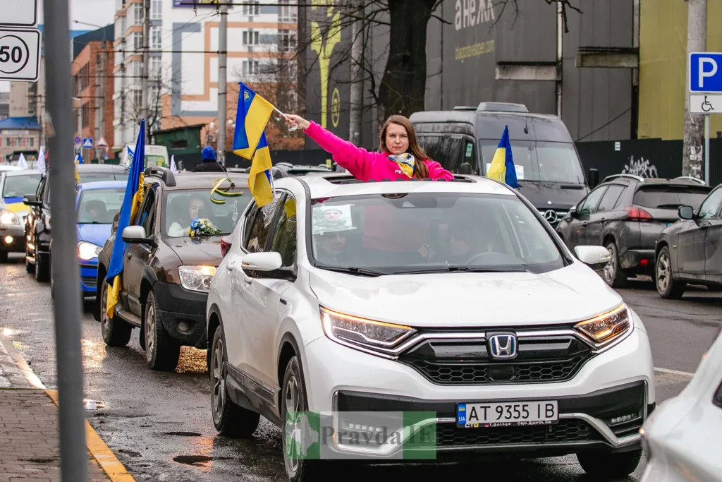 Автоколона з українськими прапорами на міській вулиці