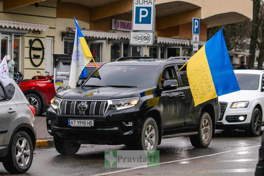 Автоколона з українськими прапорами на міській вулиці