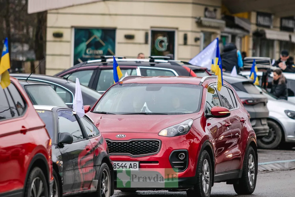 Автоколона з українськими прапорами на вулиці