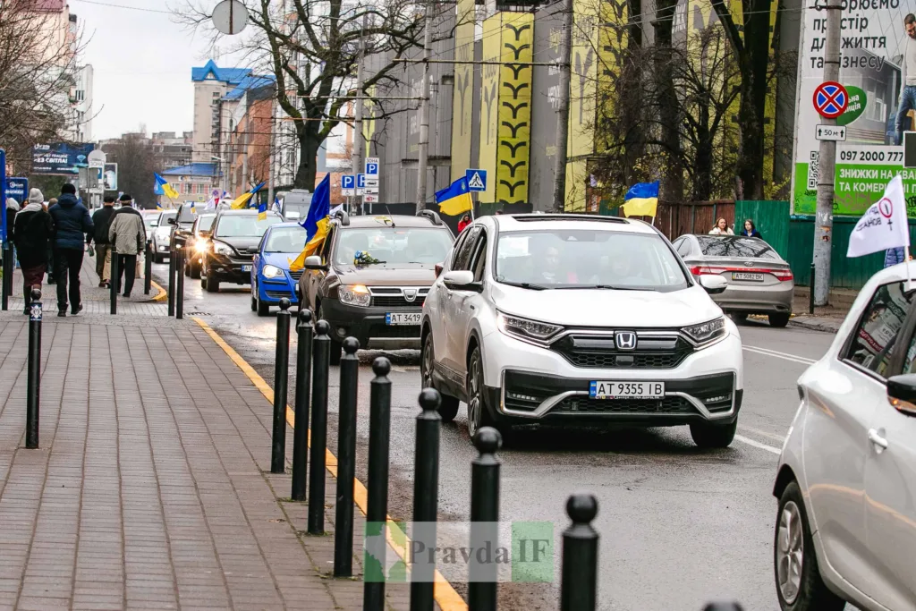 Автоколона з українськими прапорами на міській вулиці