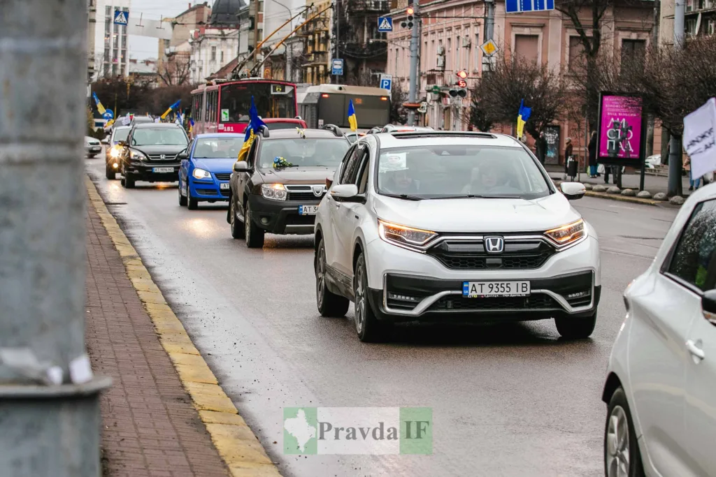 Автоколона з українськими прапорами на міській вулиці