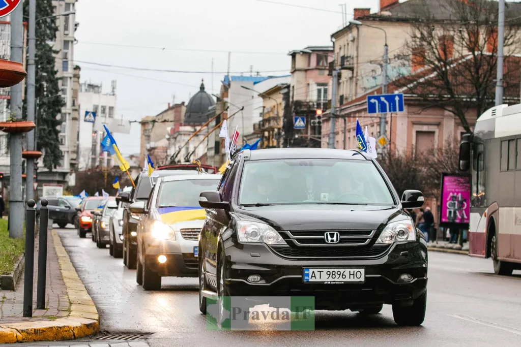Автоколона з українськими прапорами на міській вулиці