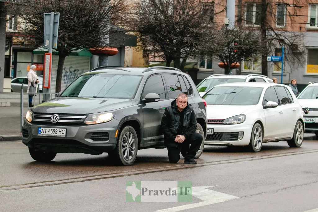 Чоловік біля автомобіля на міській вулиці