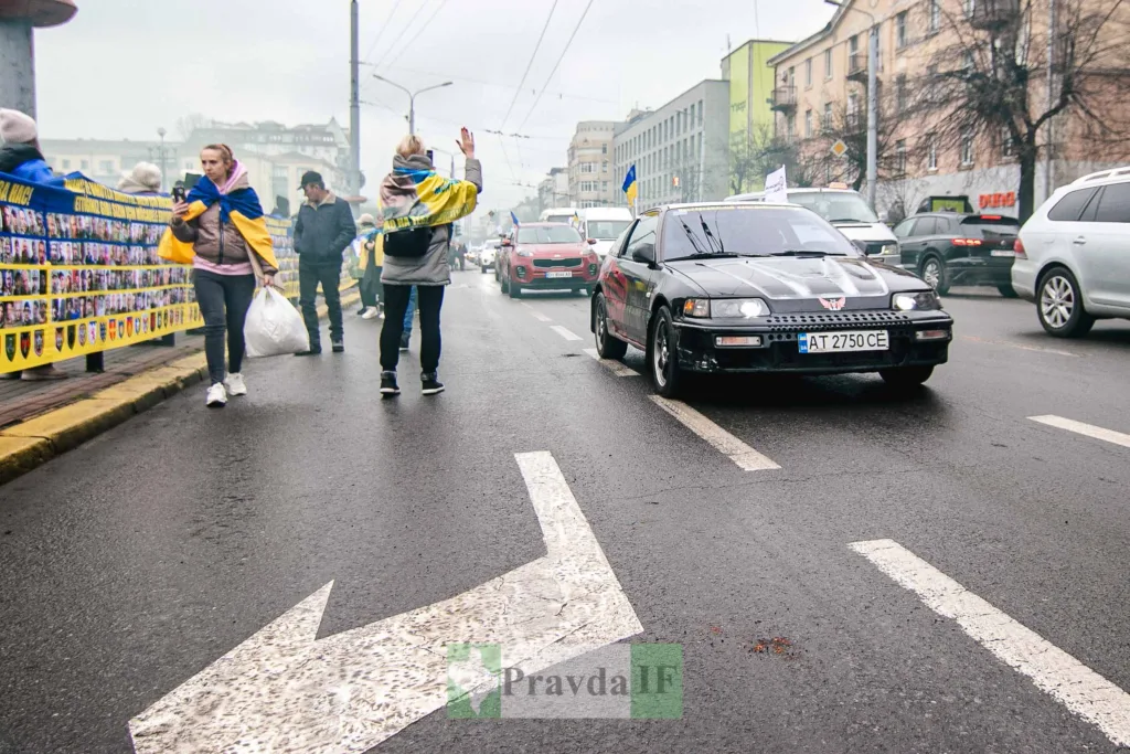 Люди з прапорами України на міській вулиці