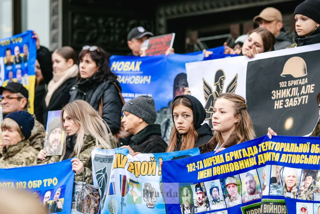 Люди тримають плакати на мітингу за військових