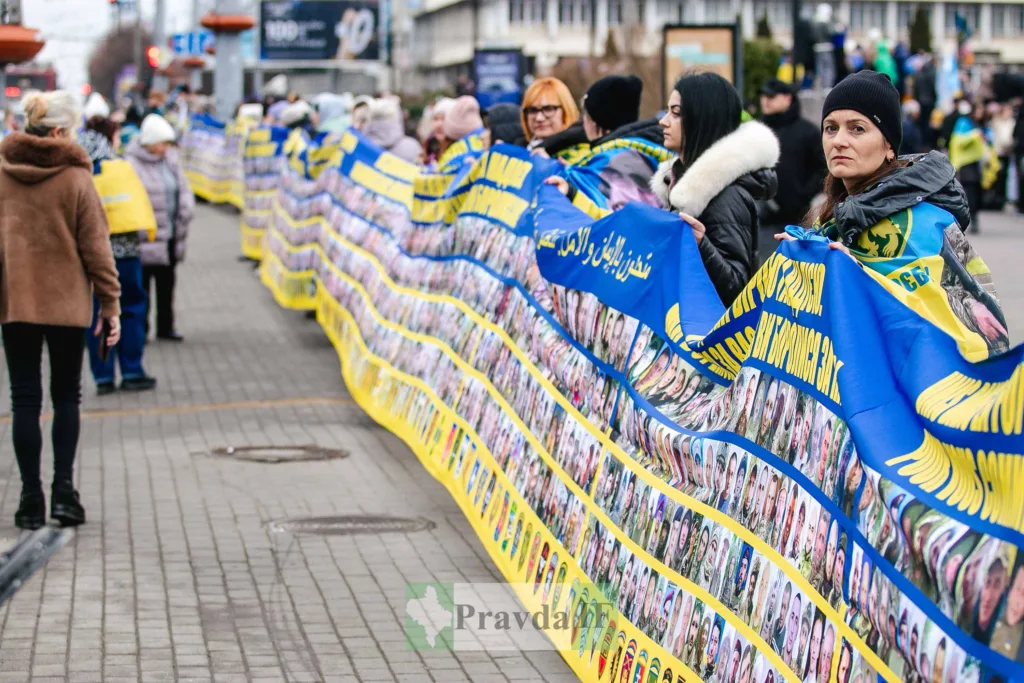 Українці тримають банер із фото військовополонених.