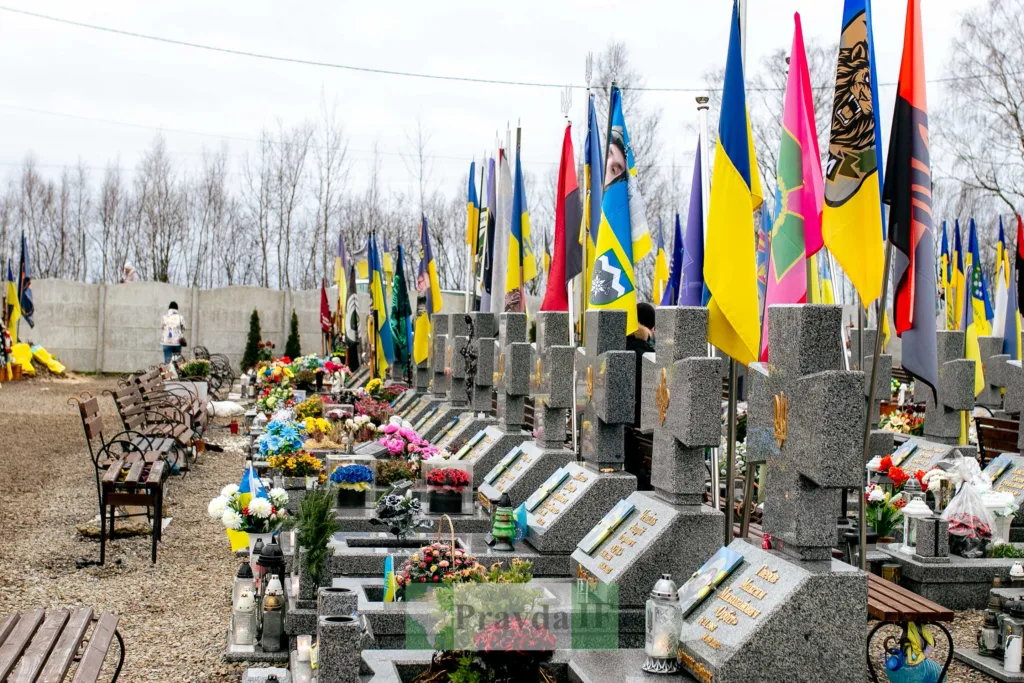 Могили захисників України з прапорами та квітами