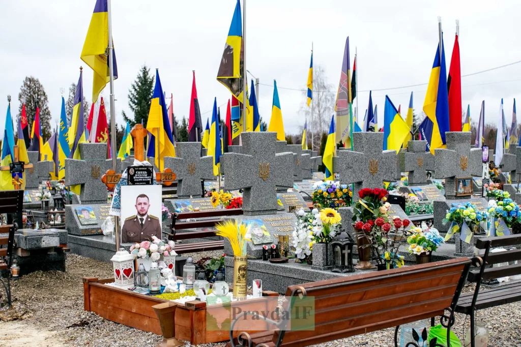 Український військовий цвинтар із прапорами та квітами