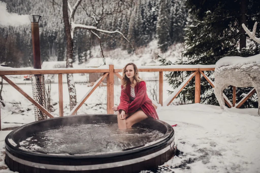 Жінка відпочиває в гарячій бочці на снігу