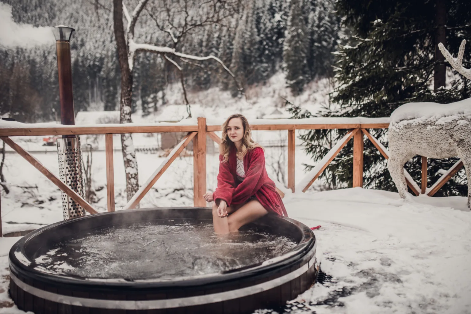 Жінка відпочиває в гарячій бочці на снігу