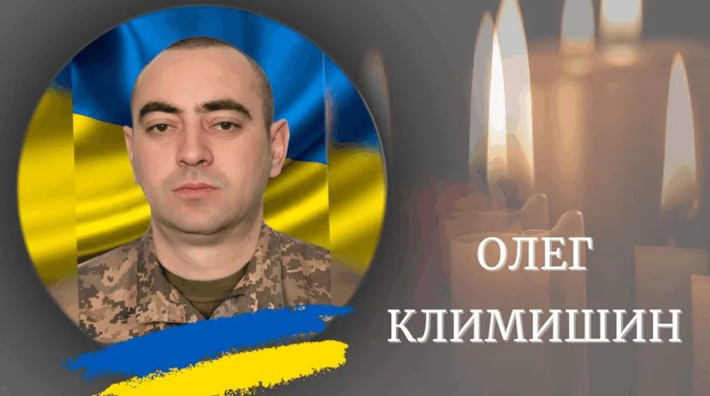 Український військовий на тлі прапора та свічок