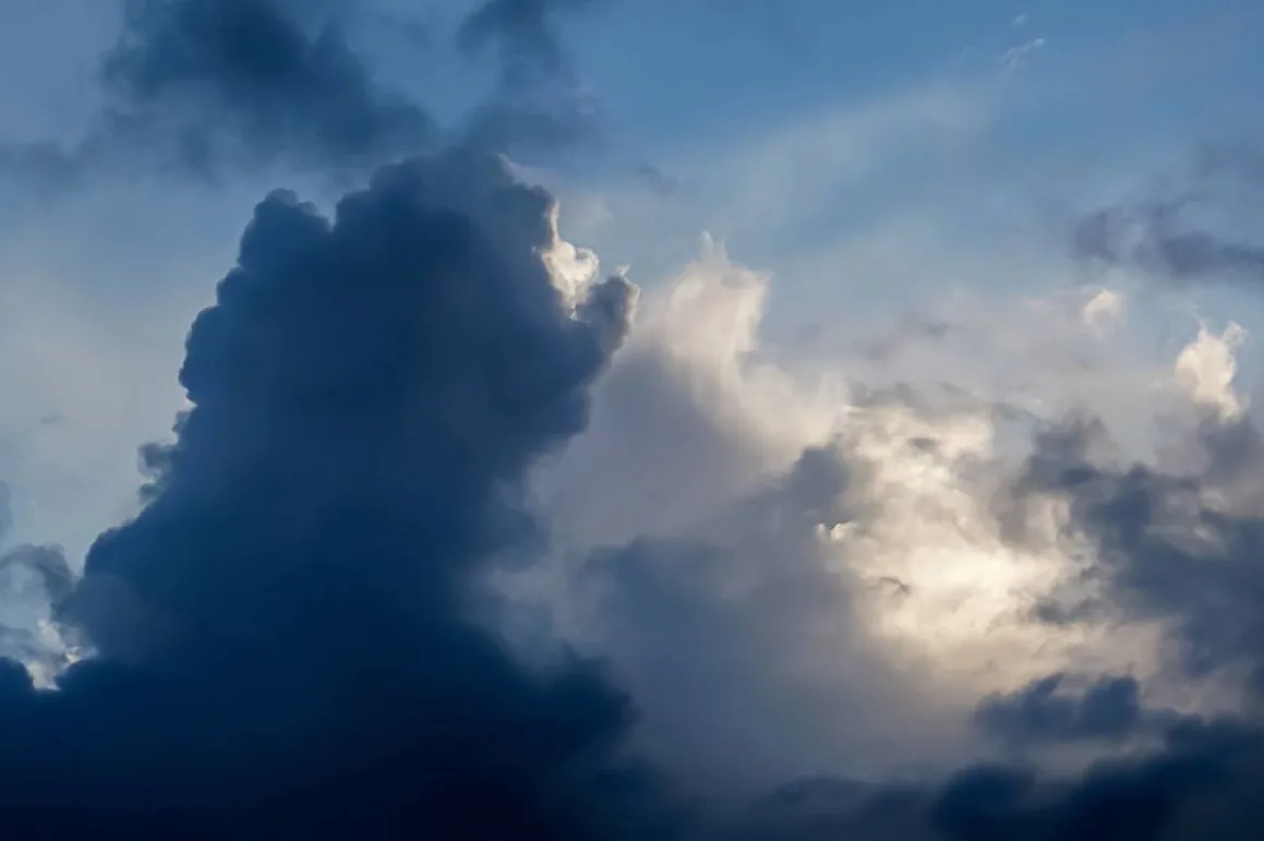 Темні грозові хмари на синьому небі